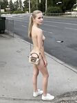 Amazing young beauty posing naked on the city street